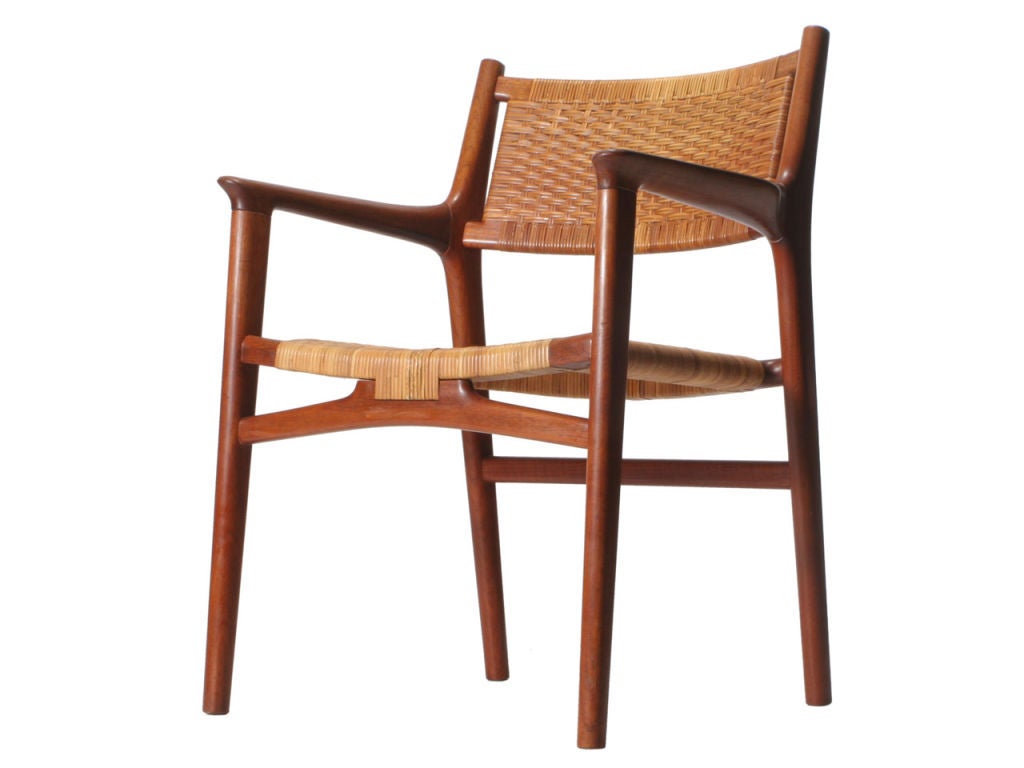 A teak armchair retaining the original cane seat and back.
