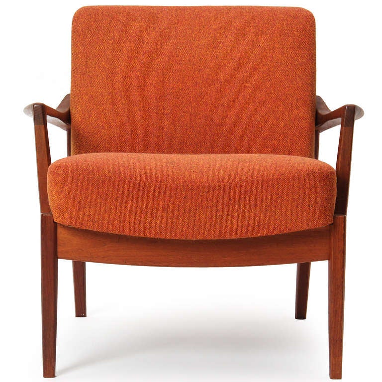 Ein Sessel mit Teakholzrahmen, dramatisch abgewinkelter dreieckiger Rückenlehne und Armlehnen, der seine ursprüngliche Polsterung aus gebrannter orangefarbener Wolle beibehält.
Maße: 22