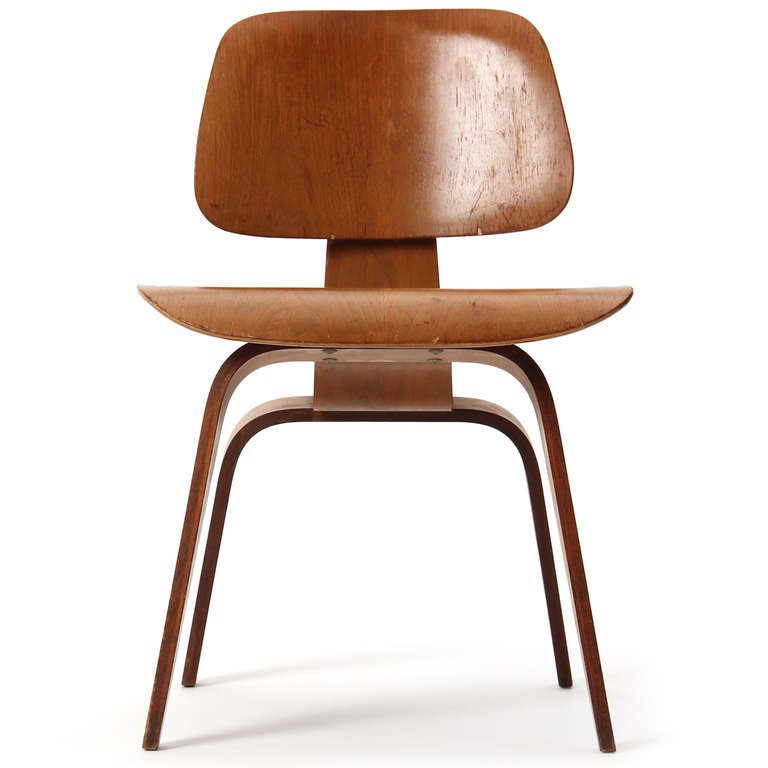 An early, Mid-Century Modern oak 'DCW' dining chair designed by Charles Eames with a double shock-mount to the backrest. Manufactured by Herman Miller in the USA, circa 1950s.