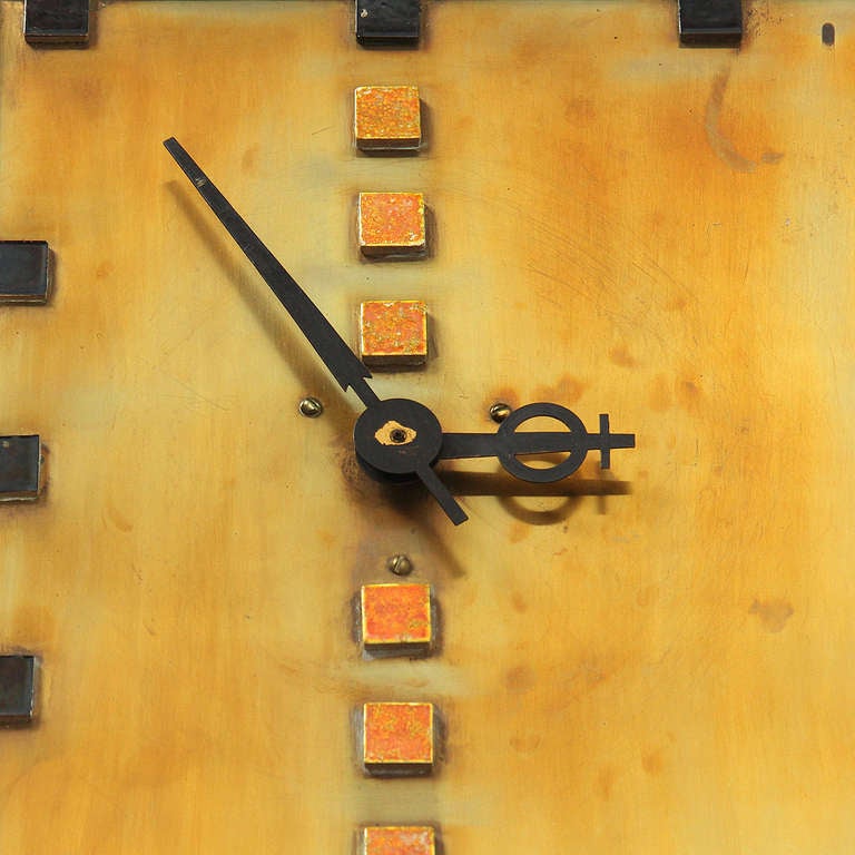 An unique wall clock with an enameled elongated rectangular face, off-center dials and square hour markers.