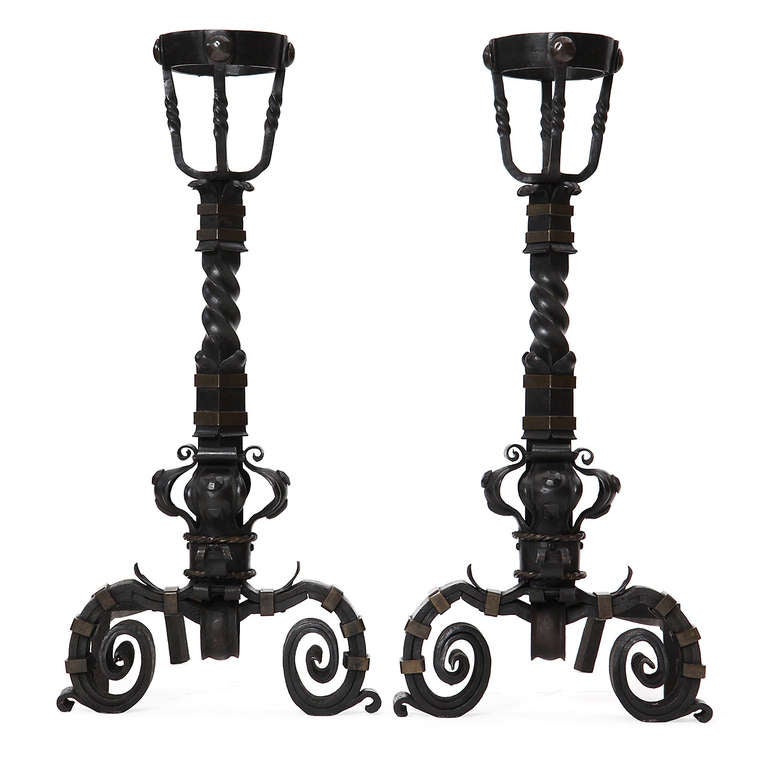 A pair of large andirons with basket tops made to hold and warm brandy bottles.