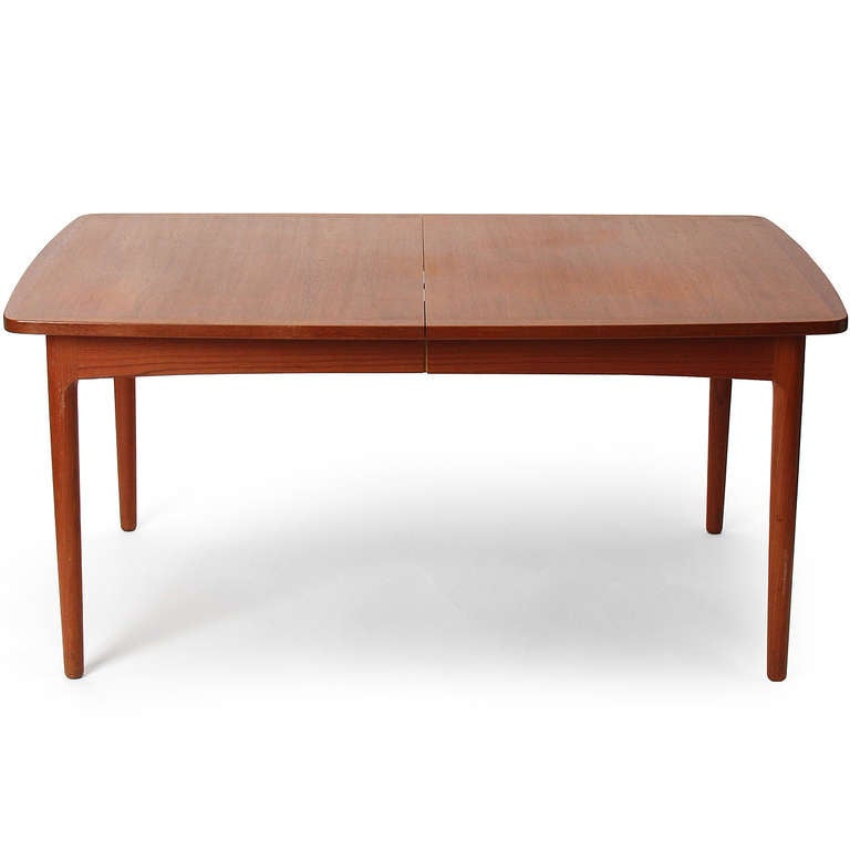A rectangular expandable dining table in teak with three extra leaves.