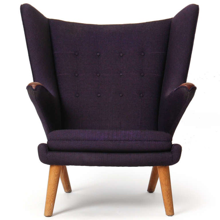 A Papa Bear wing-back armchair with exposed teak arms and tapered dowel legs retaining its original purple wool upholstery.