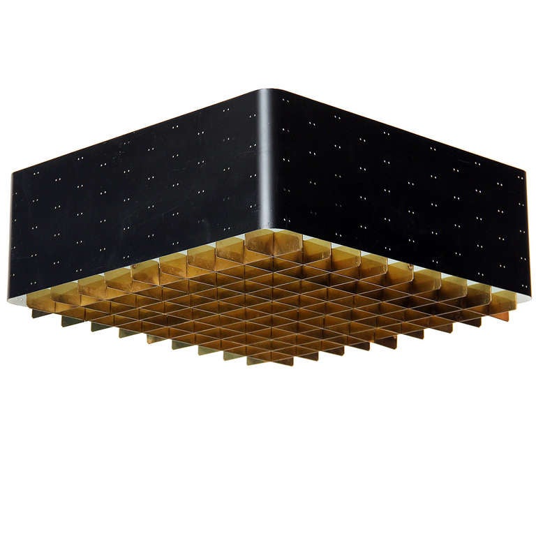 A rare perforated ebonized steel flush-mount ceiling fixture having a frosted glass insert resting on a graphic brass grid diffusion screen. Not shown with support column. Shade is 5.5