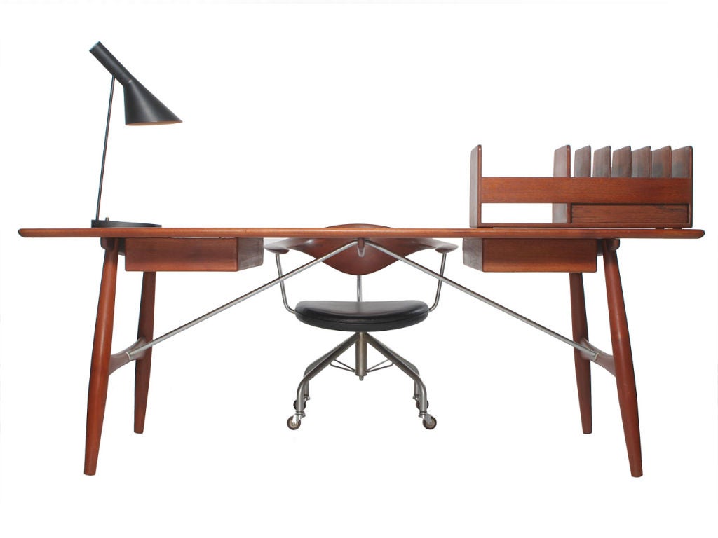 A rare desk with a solid teak top over two drawers, on turned teak legs with satin chromed steel rod braces. Designed by Hans Wegner cabinetmaker Johannes Hansen.(chair, lamp, and desk organizer available separately.)