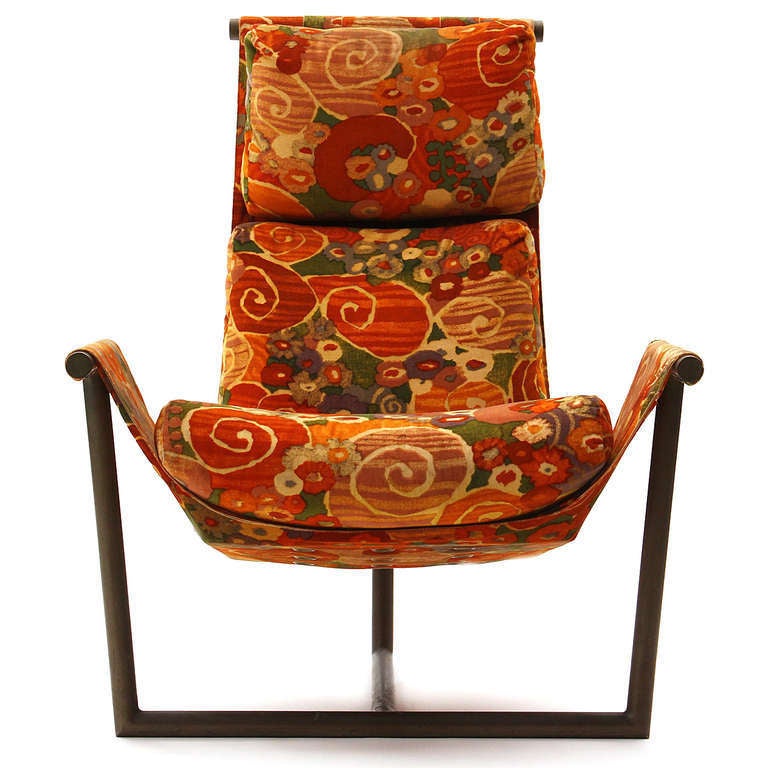Spare and expressive - a sling of fabric and upholstery is suspended between three points of a patinated architectural metal frame.This chair retains its original vibrant Jack Lenor Larsen fabric.