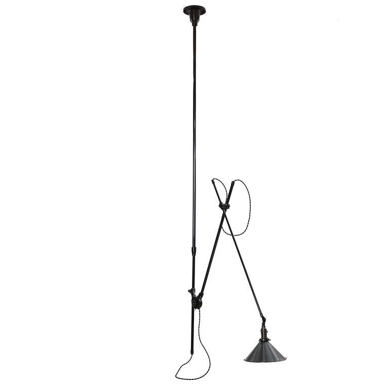 A ceiling-mounted and fully articulated industrial lamp having a rich dark patinated finish, steel conical shade and a sculptural cast iron ceiling plate.