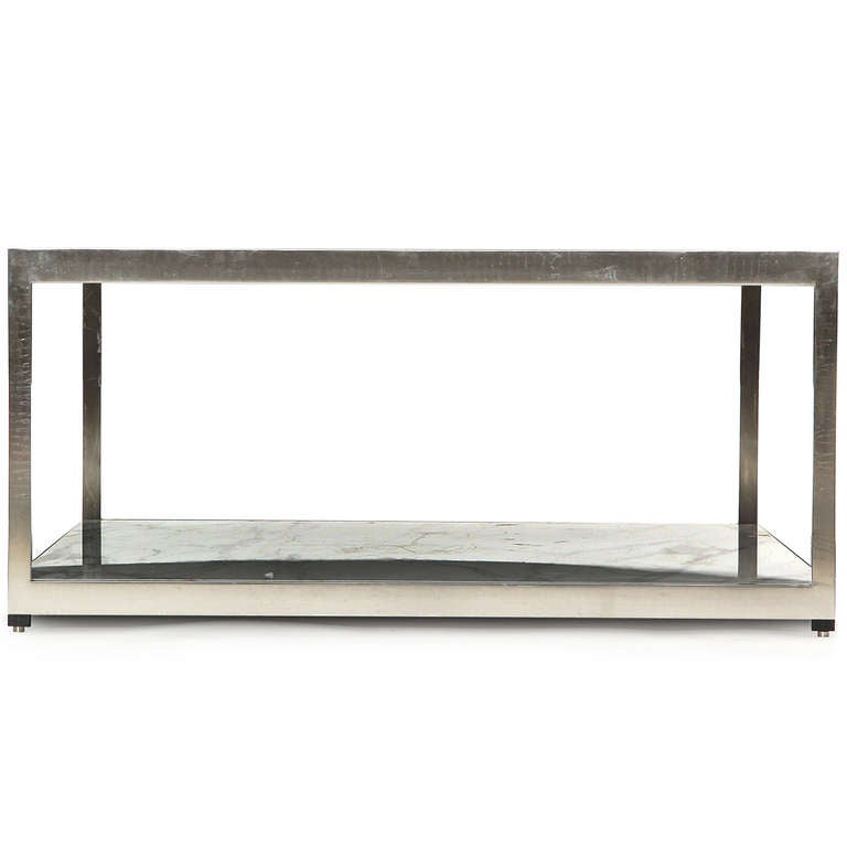 A refined and elegant rectilinear coffee or low table having an exposed stainless steel frame supporting two figured Carrara marble slabs.