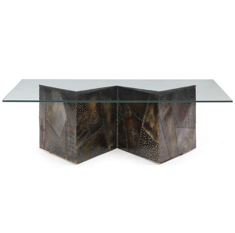 A dramatic and expressive studio low table having a hand-made zig-zag shaped base of welded, textured and patinated steel supporting a glass top.