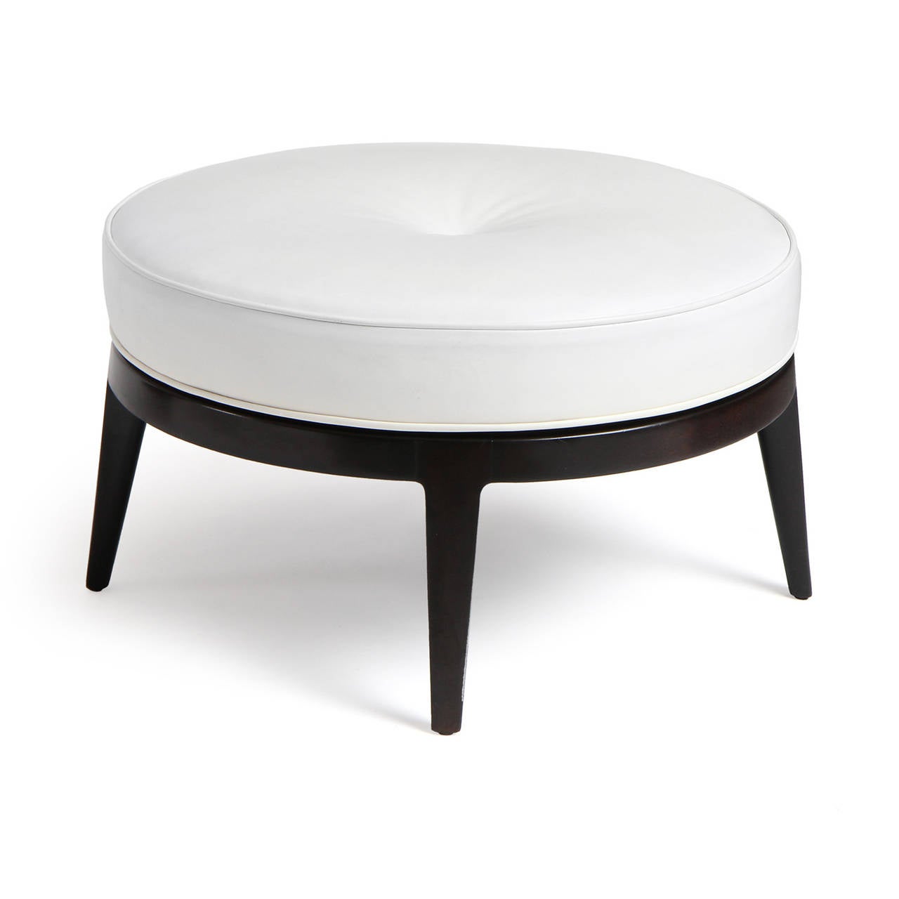 An uncommon and elegant circular swivel-seat ottoman finely upholstered in leather on a lacquered base with splayed and tapered legs.