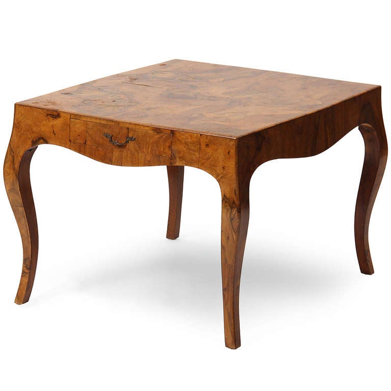 A well-crafted sculptural end table with serpentine legs made using an expressive olive burl.