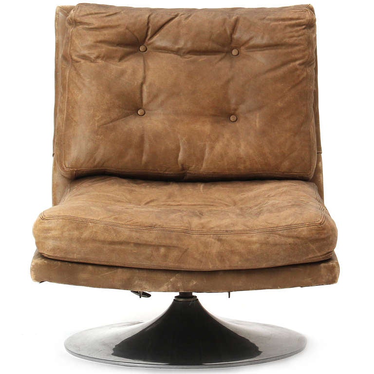 A comfortable pair of tufted armless lounge chairs in leather on swiveling chromed steel pedestal bases.