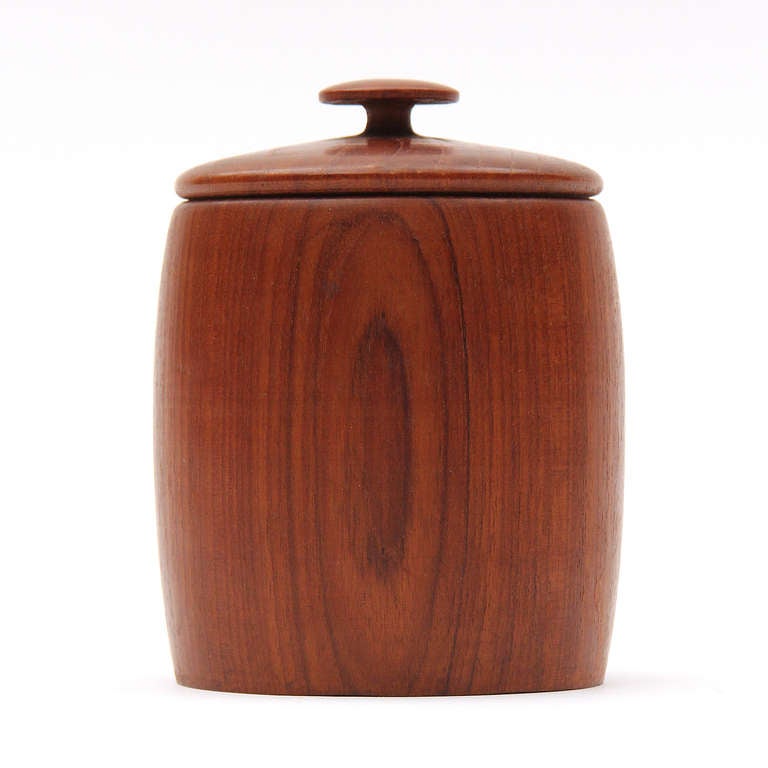 A set of 8 hand turned teak drinks coasters housed in a lidded storage container.