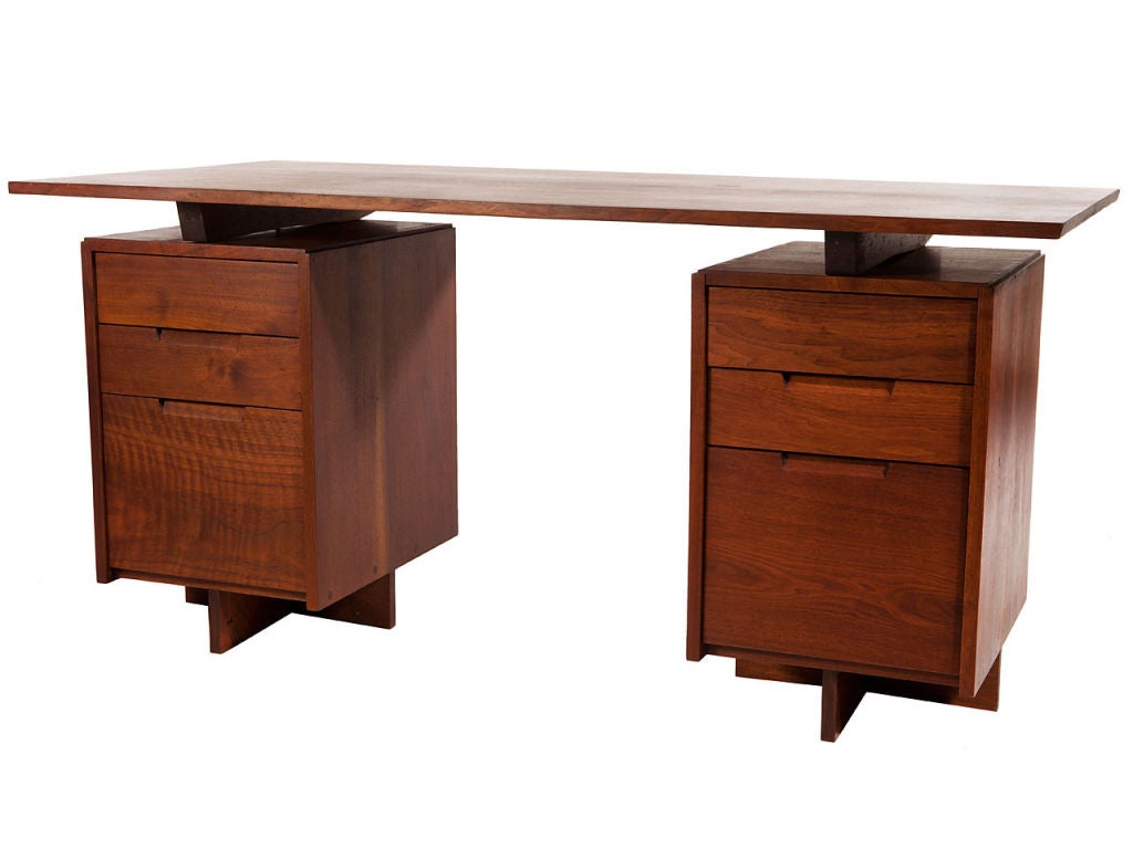 Walnut slab top floats over three drawer cabinets.<br />
Designed and made by George Nakashima Studio