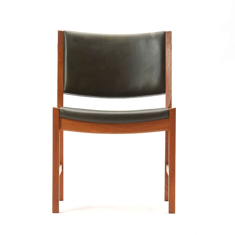 Un ensemble rare de quatre (4) chaises de salle à manger sans bras conservant la tapisserie originale en cuir d'oxide vert.