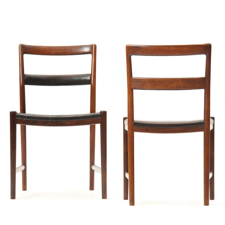 A fine. sculptural and rare set of 12 rosewood dining chairs (eleven side chairs and one arm chair), all with leather upholstered seats and back rails; constructed by cabinet maker Peder Pedersen.