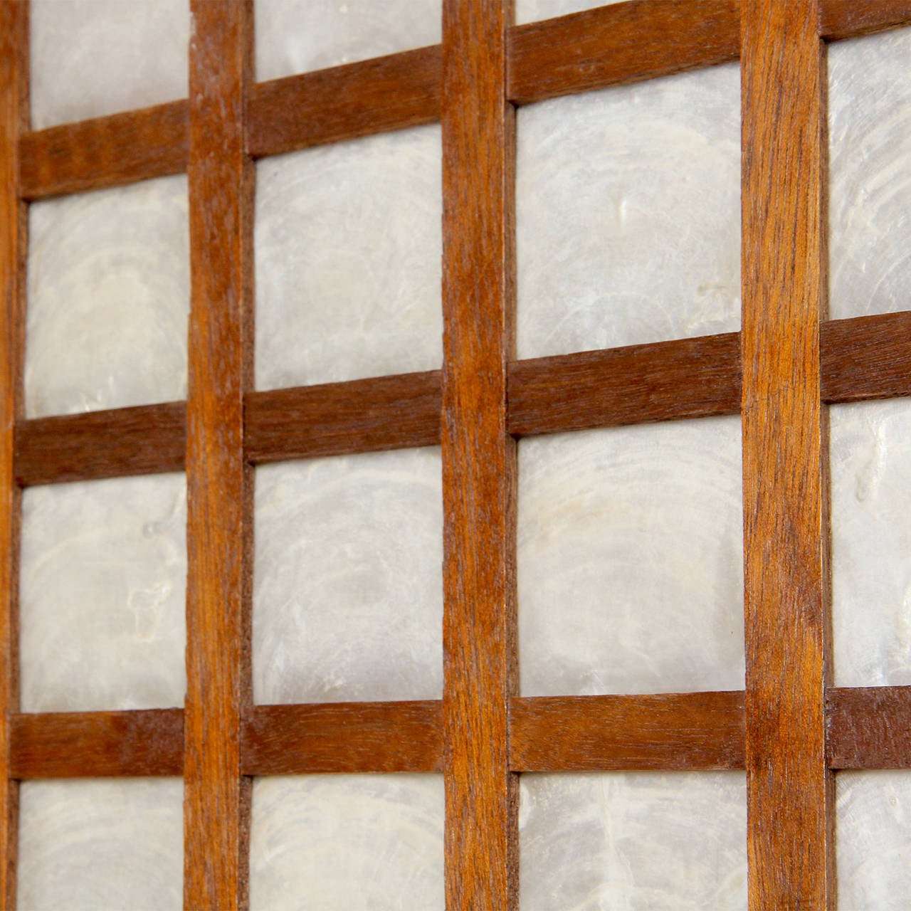 A well scaled and finely crafted gridded panel having a handmade lap jointed mahogany frame and inset with expressive and translucent squares of capiz shell.