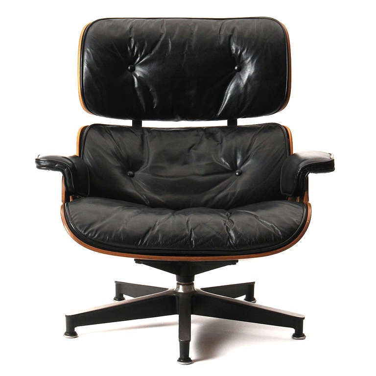 A beautiful example of the Eames swiveling lounge chair and ottoman, having a highly figured laminated rosewood shell and its original fitted black leather upholstery.
