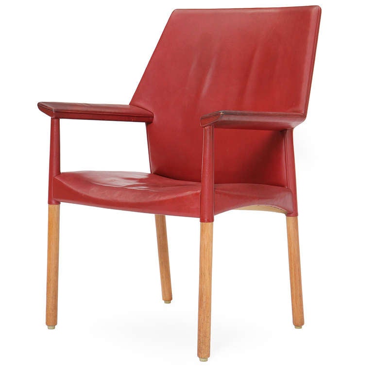 A superb armchair having an open oak frame with subtly angled arms and retaining its rich aniline-red leather upholstery.