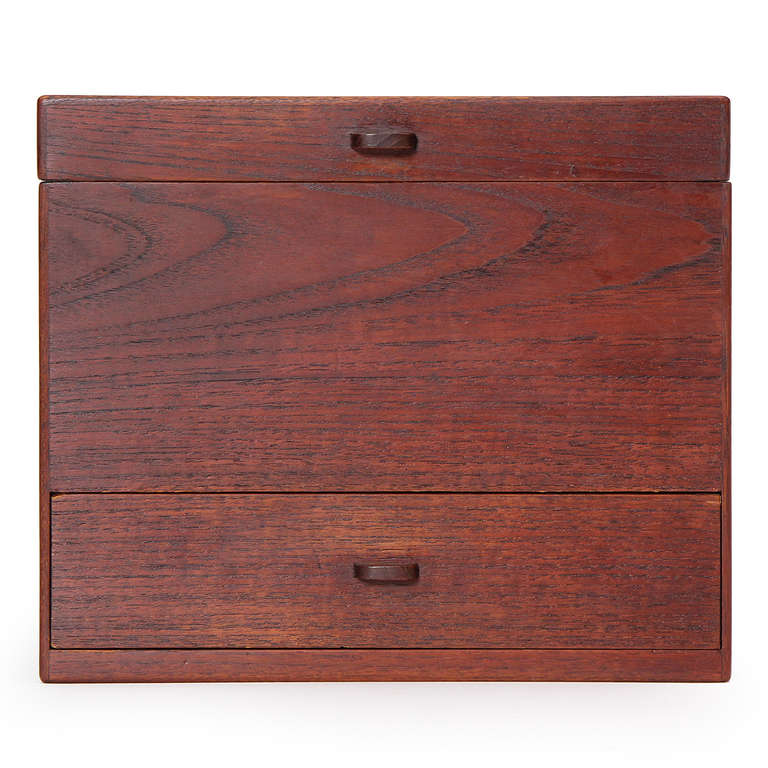 A handcrafted jewelry box with a mirrored lid and a single treasure drawer, all executed in teak.