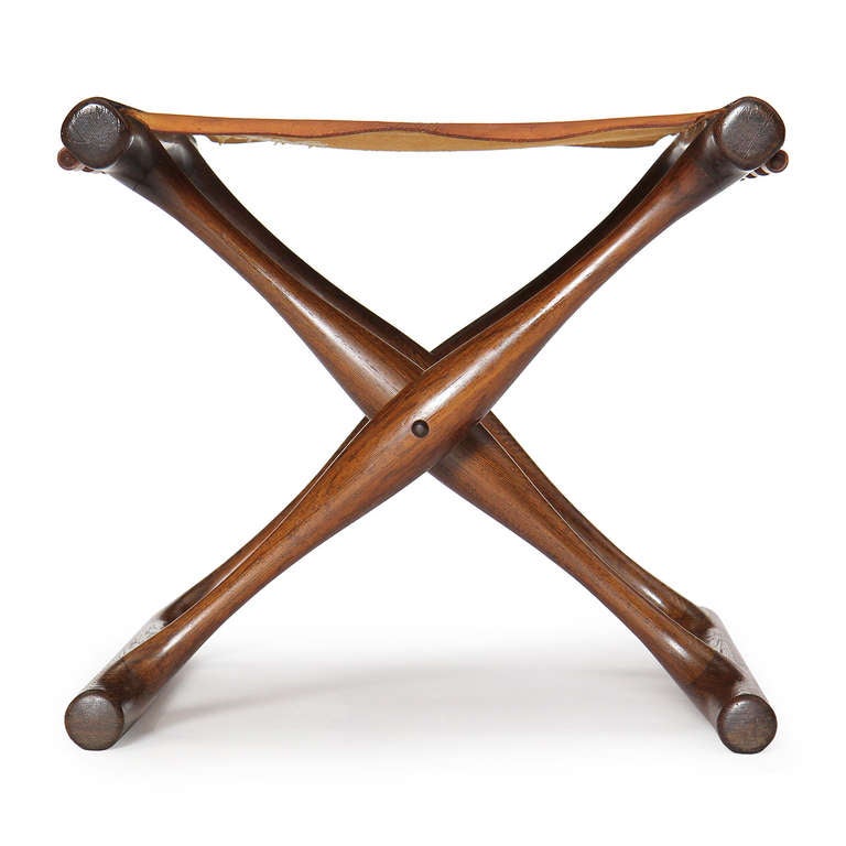 A superb folding stool having a sculptural frame of rich wenge wood and a thick natural leather sling seat. Hundevad based the design after an ancient Bronze-Age archetype in the National Museum of Denmark.