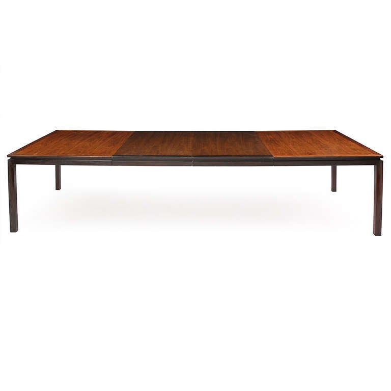 An elegant and restrained expandable mahogany and walnut rectangular dining table showing a Classical Chinese influence for Dunbar's Janus line.