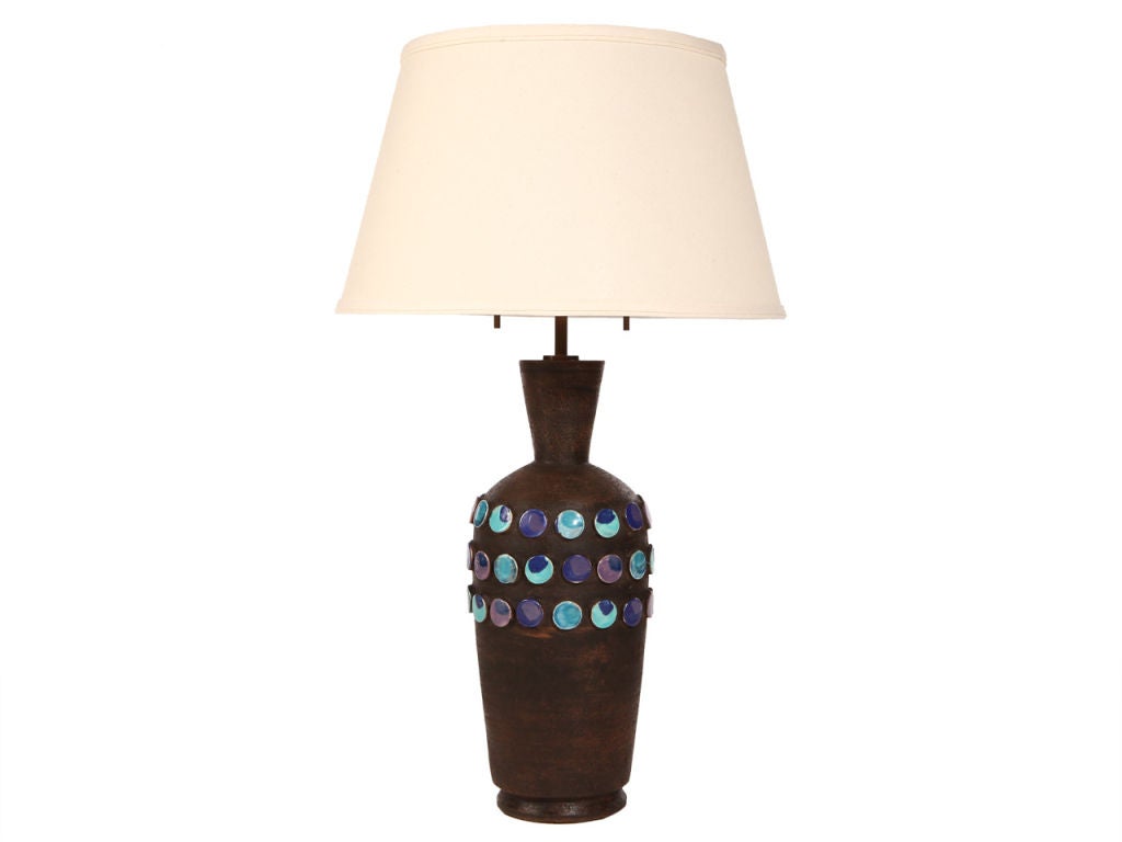 A ceramic lamp in brown matte glaze with applied purple and blue circular tiles.