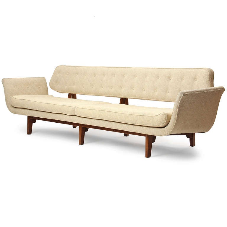 A rare and expressive Wormley design, the Gondola sofa has a floating, buttoned backrest and loose seat cushion on an exposed notched and buttressed mahogany frame.