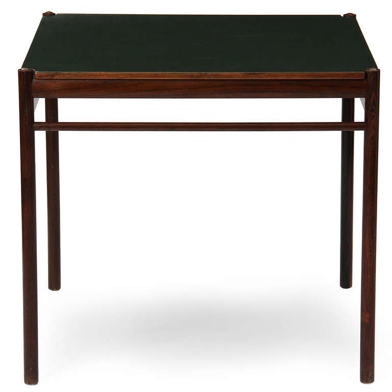 A game table with a reversible wood / green leather, sitting on top of simple dowel legs.