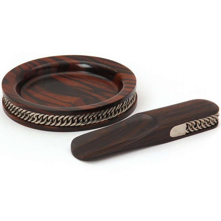 A set of men's accessories which includes a rosewood coin bowl and shoehorn both wrapped with a recessed sterling silver chain. 