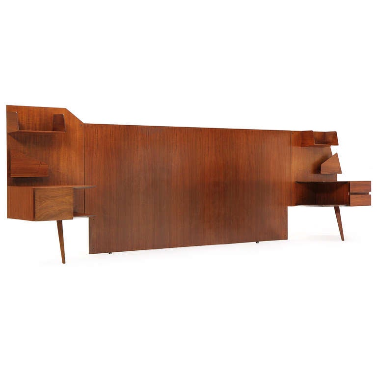 An amazing architectural king­sized headboard constructed with solid walnut floating cantilevered shelves and storage.