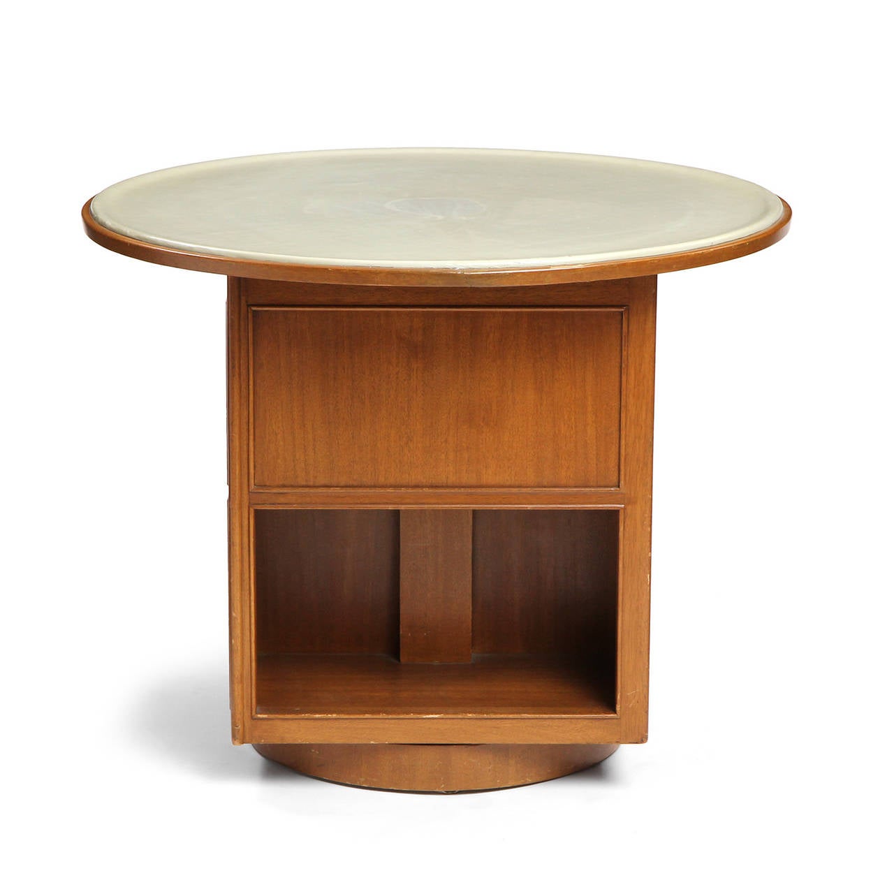 An uncommon architectural occasional table with a circular leather wrapped top that floats on a four sided Walnut square base with staggered recessed shelves. The entire table rotates on a lazy-susan style disc base.