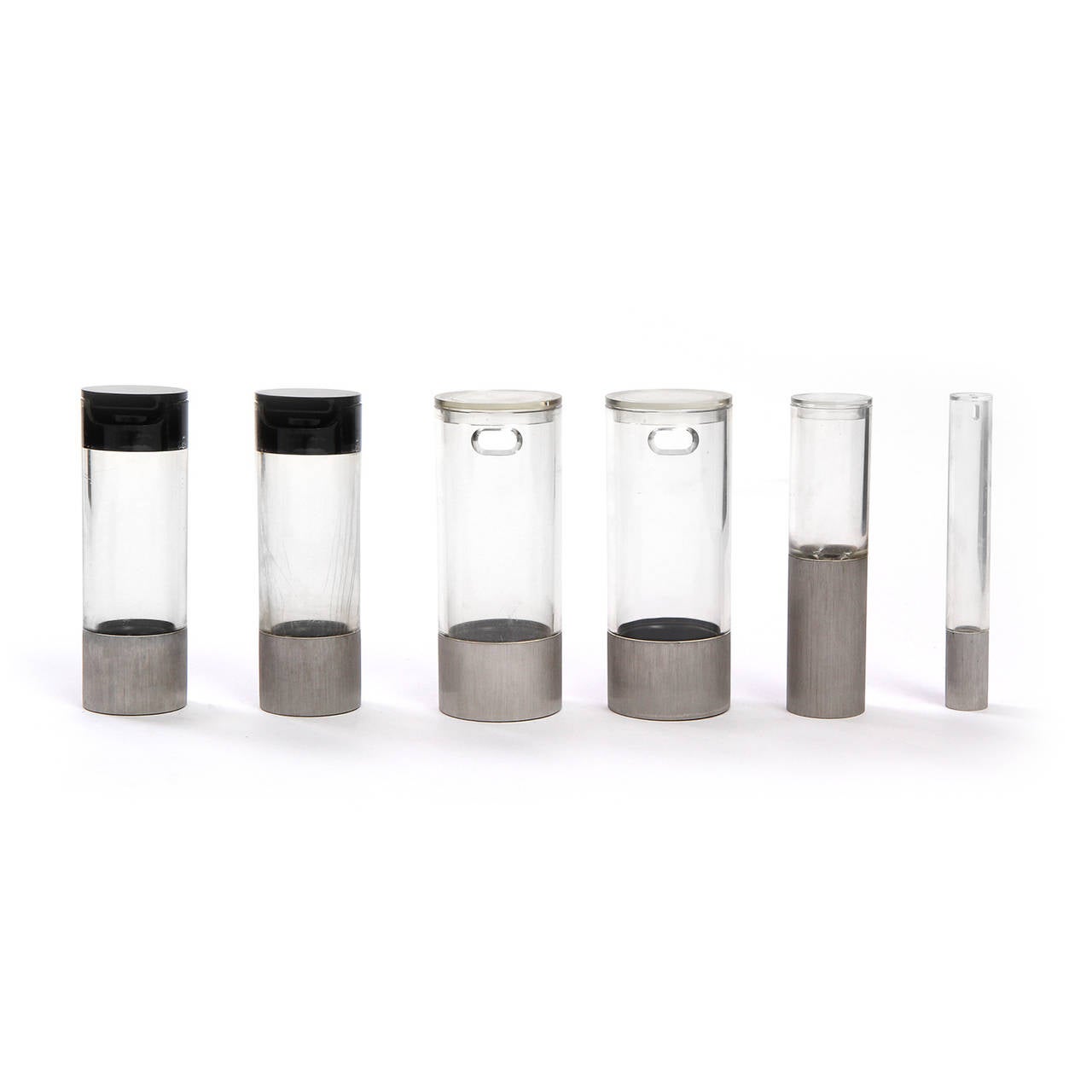 A masterfully designed modernist condiment tray of impeccable quality, the elements (salt shaker and pepper mill, oil and vinegar containers) made of Lucite and stainless steel are housed vertically in a fitted revolving circular stainless steel