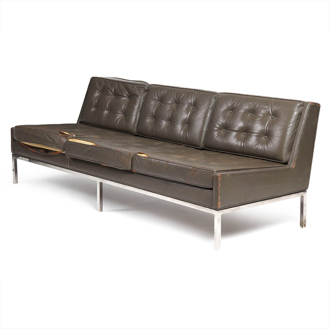 An uncommon, arm less three seat sofa with tufted leather cushions having a spare and architectural chromed steel six legged base. Still in original leather.