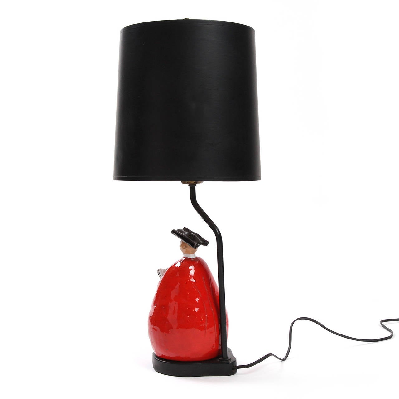 A delightful and graphic unique ceramic table lamp featuring a vividly glazed handcrafted parson holding an open book.