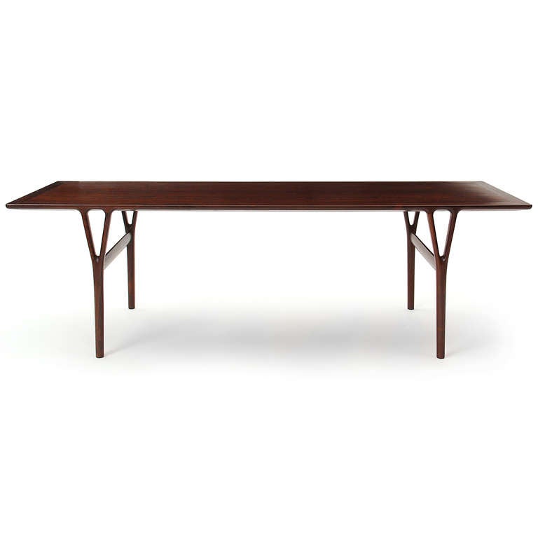 An elegant and beautifully constructed narrow low table in rosewood having a bevel-edged top on sculptural Y-form legs