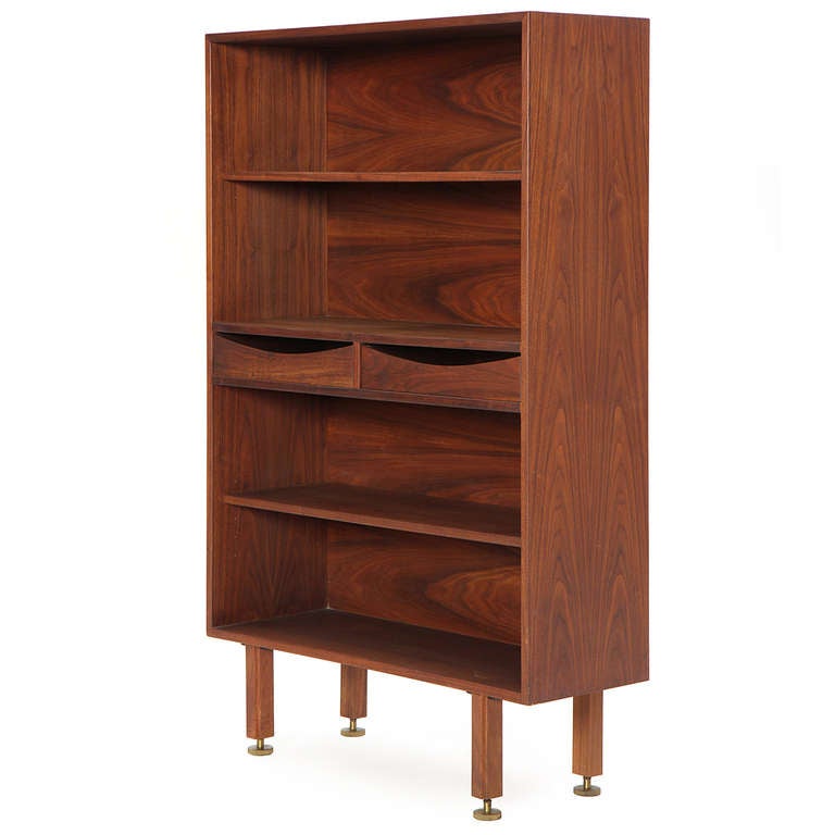 An excellent legged walnut bookcase with a small drawer nested between open shelves.