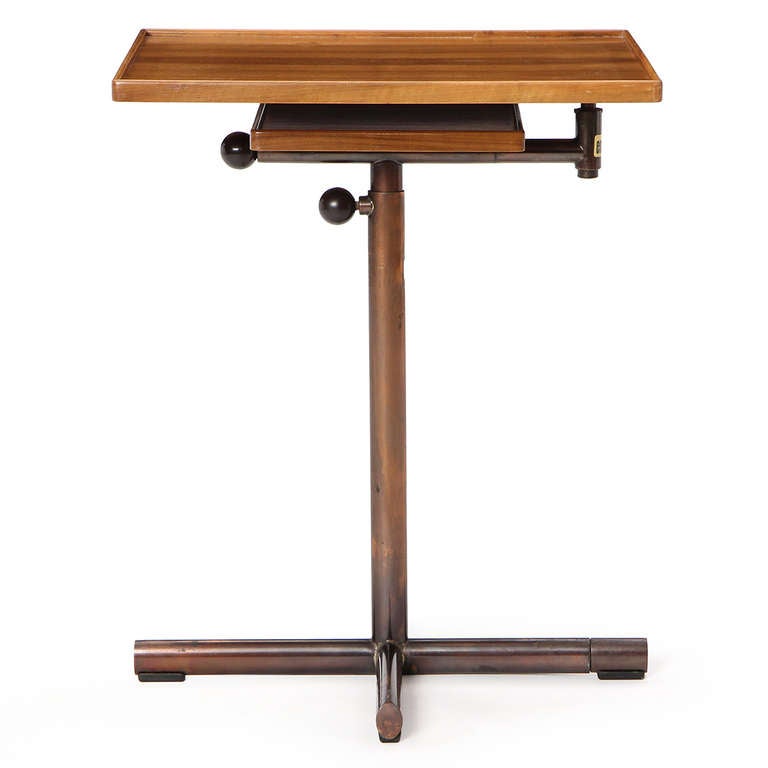 A utility table workstation with a walnut top and copper plated steel base. Upper surface swings around 90º and tilts in 5º increments.
Extends to a hight of 40