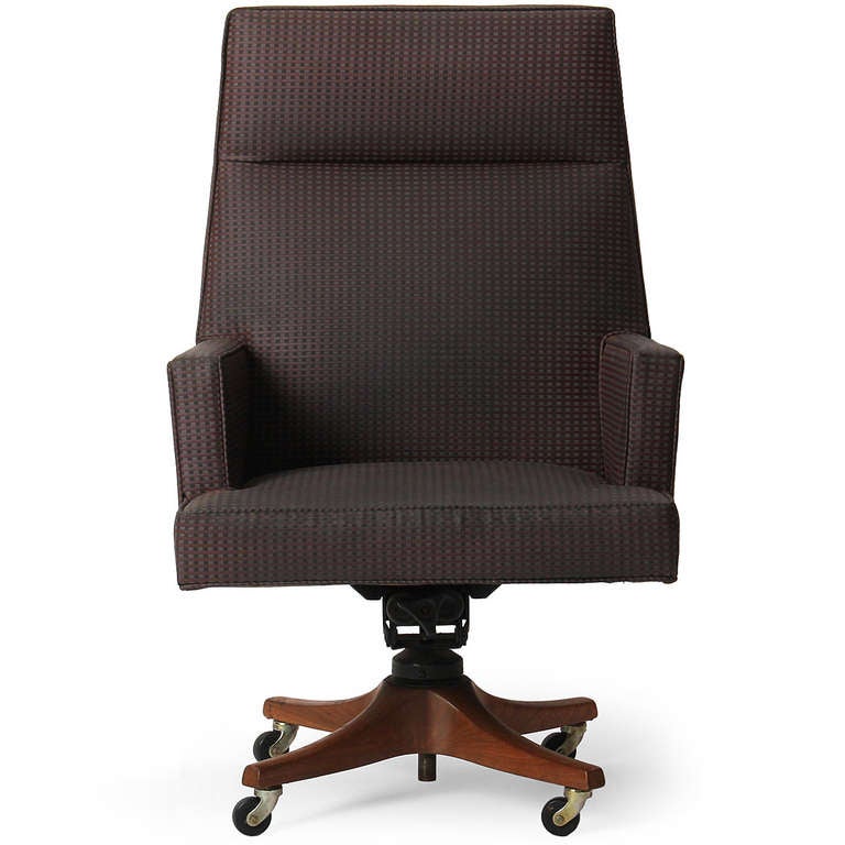 A high back adjustable executive chair (tilt and swivel) having a sculptured walnut base with steel and rubber casters.