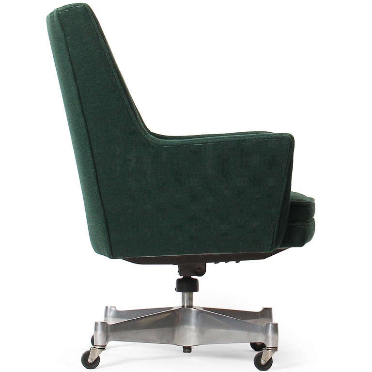 A fully upholstered and adjustable high back swiveling and rolling desk chair having a sculptural four point cast steel base.