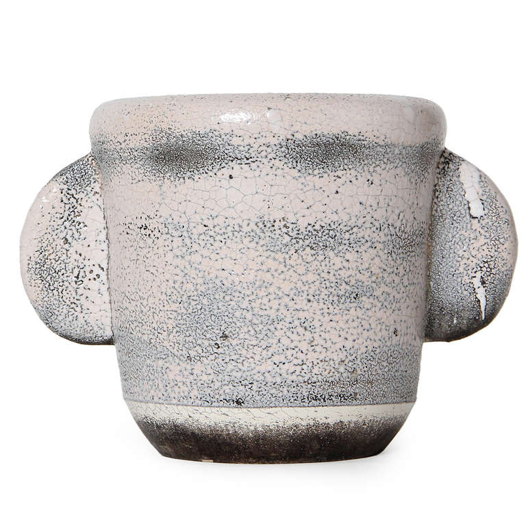 A unique turned stoneware vase in the form of an oversized mug with a pale pink, lightly applied glaze.
