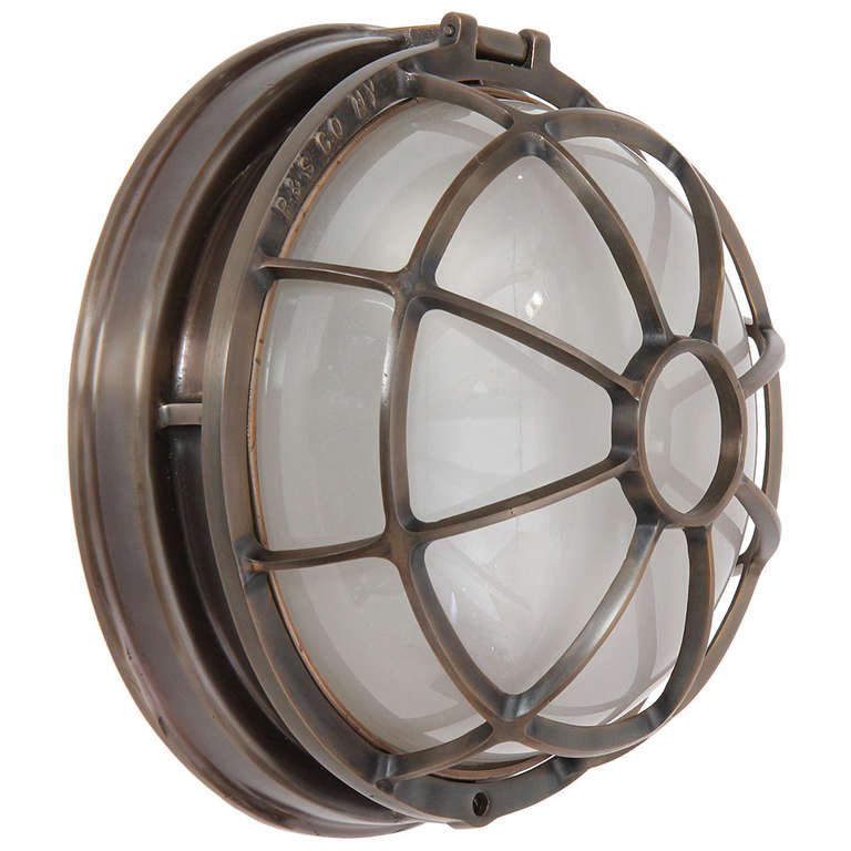 An excellent cast bronze sconce or ceiling mount lamp with two sockets underneath a glass dome protected by a well designed bronze cage.