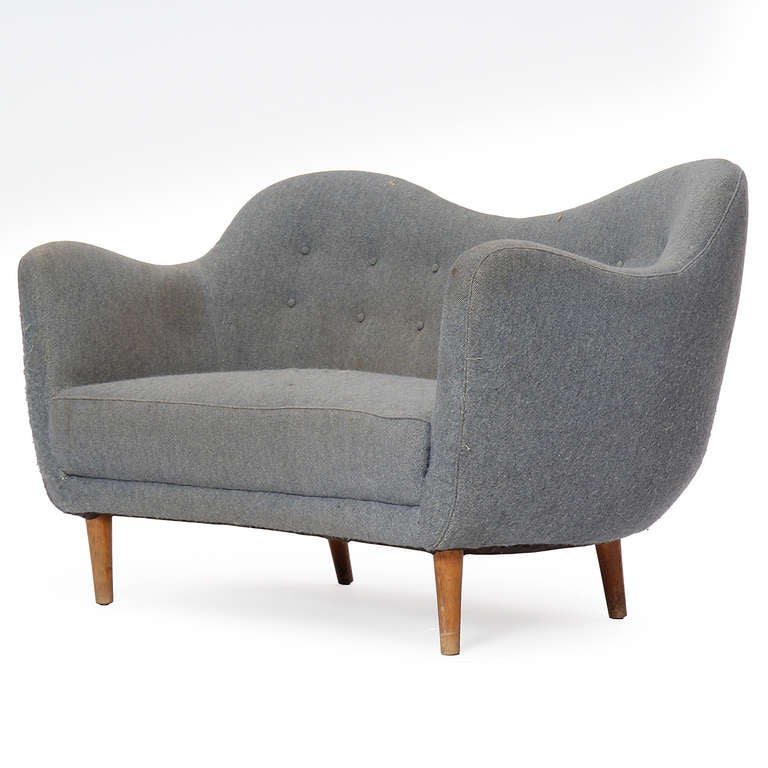 A 'Poet' sofa with an undulating backrest and tapered beech dowel legs, retaining the original wool upholstery.