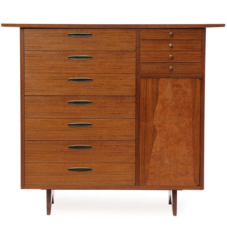 An outstanding chest of drawers in East Indian Laurel with a generous curved top over seven (7) large drawers, four (4) small drawers, and a doored cabinet with shelves.