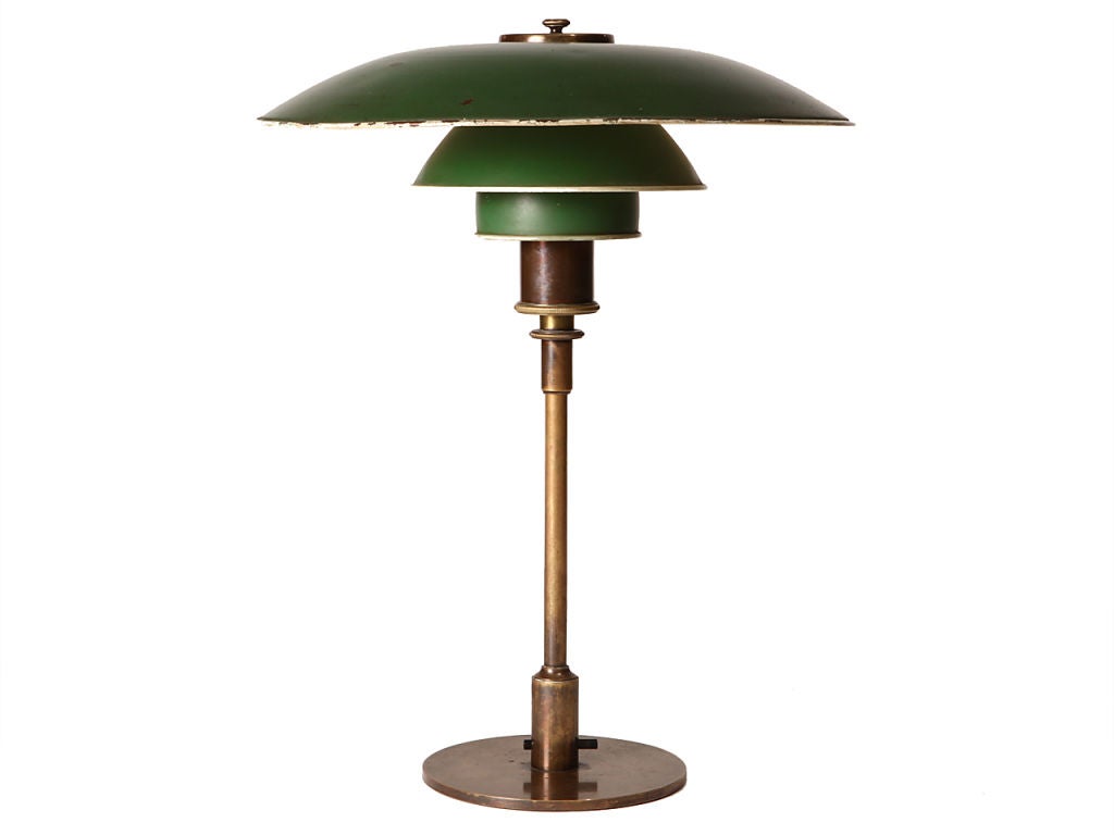 A desk lamp with three shades - retaining the original green paint - supported by a brass upright with a disc base; marked 