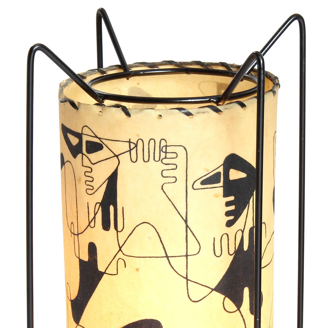 An exuberant and expressive table lamp having an exposed black metal structure supporting a suspended parchment column graphically decorated with abstracted figures.