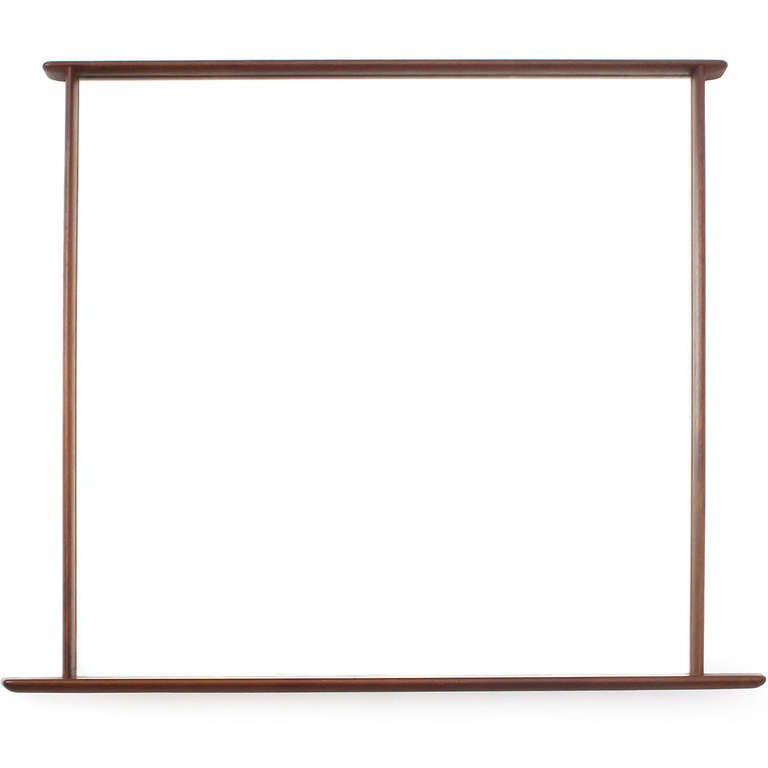 An uncommon and beautifully simple walnut wall mirror with overhanging edges by George Nakashima for his Widdicomb Sundra collection.