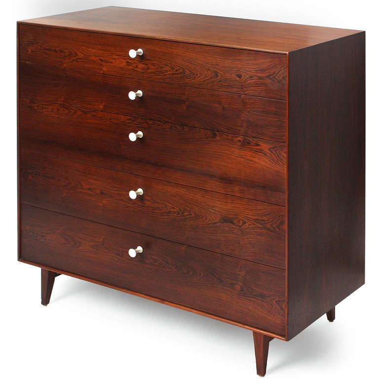 A pair of Thin Edge chests of drawers in beautifully figured rosewood having five drawers with sculptural white aluminum pulls and elegant turned aluminum legs.