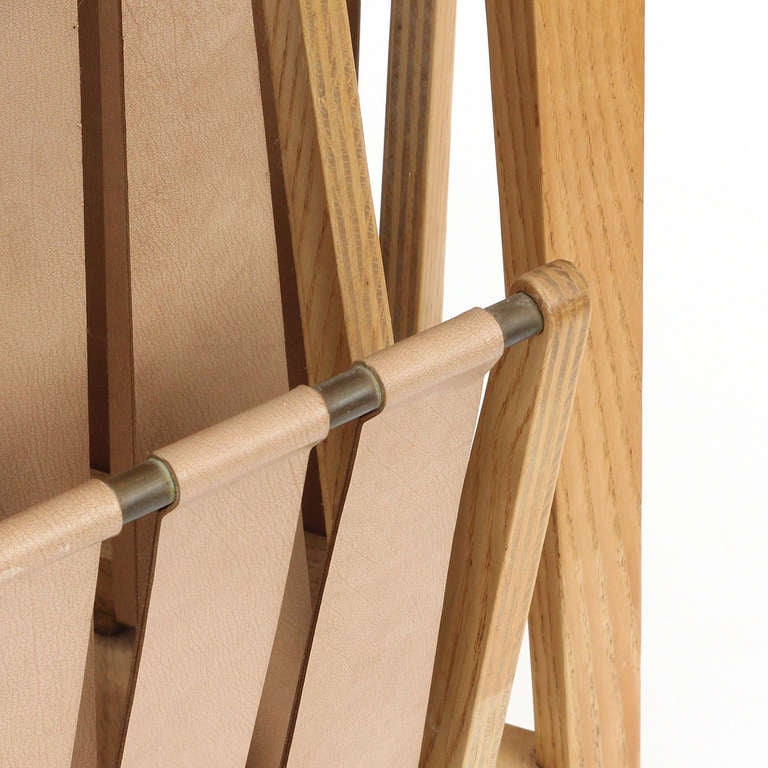 Ein dreieckiger Eschenholztisch mit einer cremefarbenen Lederplatte über zwei Gurtband-Magazinhaltern.