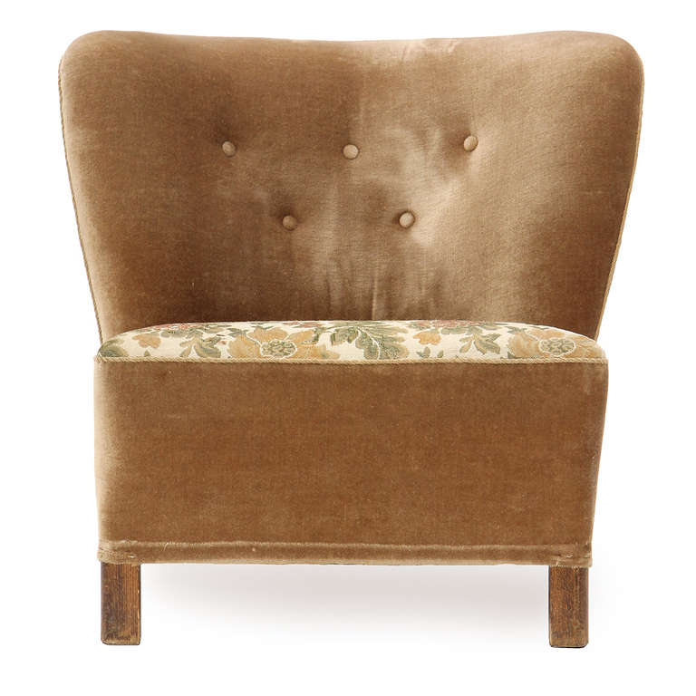 An exceptional slipper chair with a gently curved back and a generous seat upholstered in a light brown velvet.